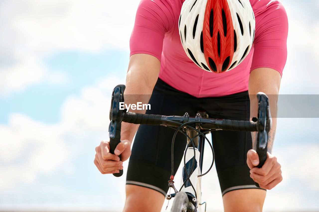 Man riding bicycle against sky