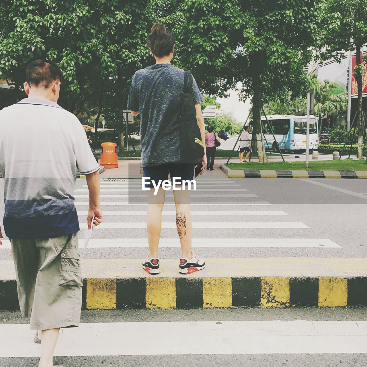 Rear view of men on zebra crossing