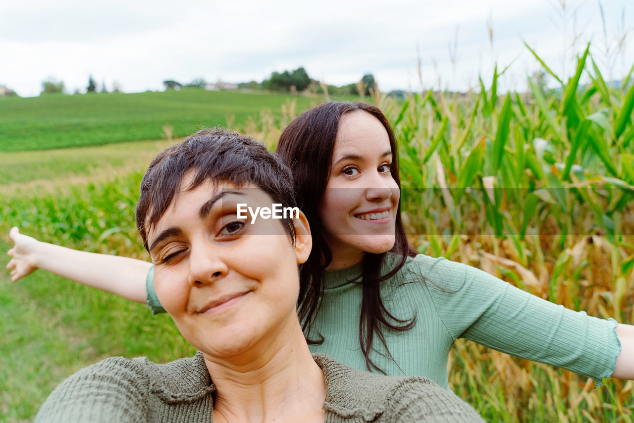 PORTRAIT OF A SMILING YOUNG WOMAN IN FIELD