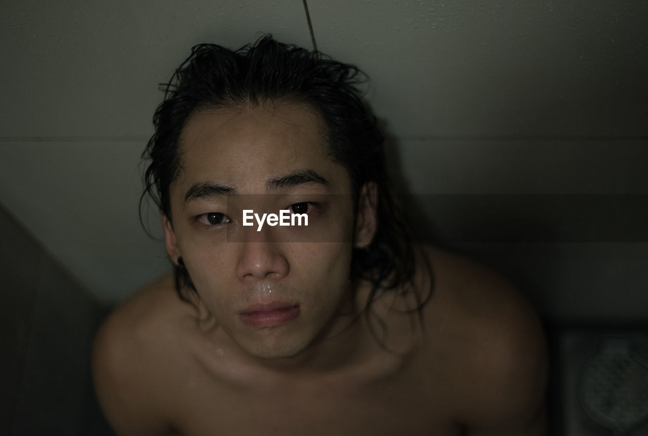 PORTRAIT OF YOUNG WOMAN IN BATHROOM