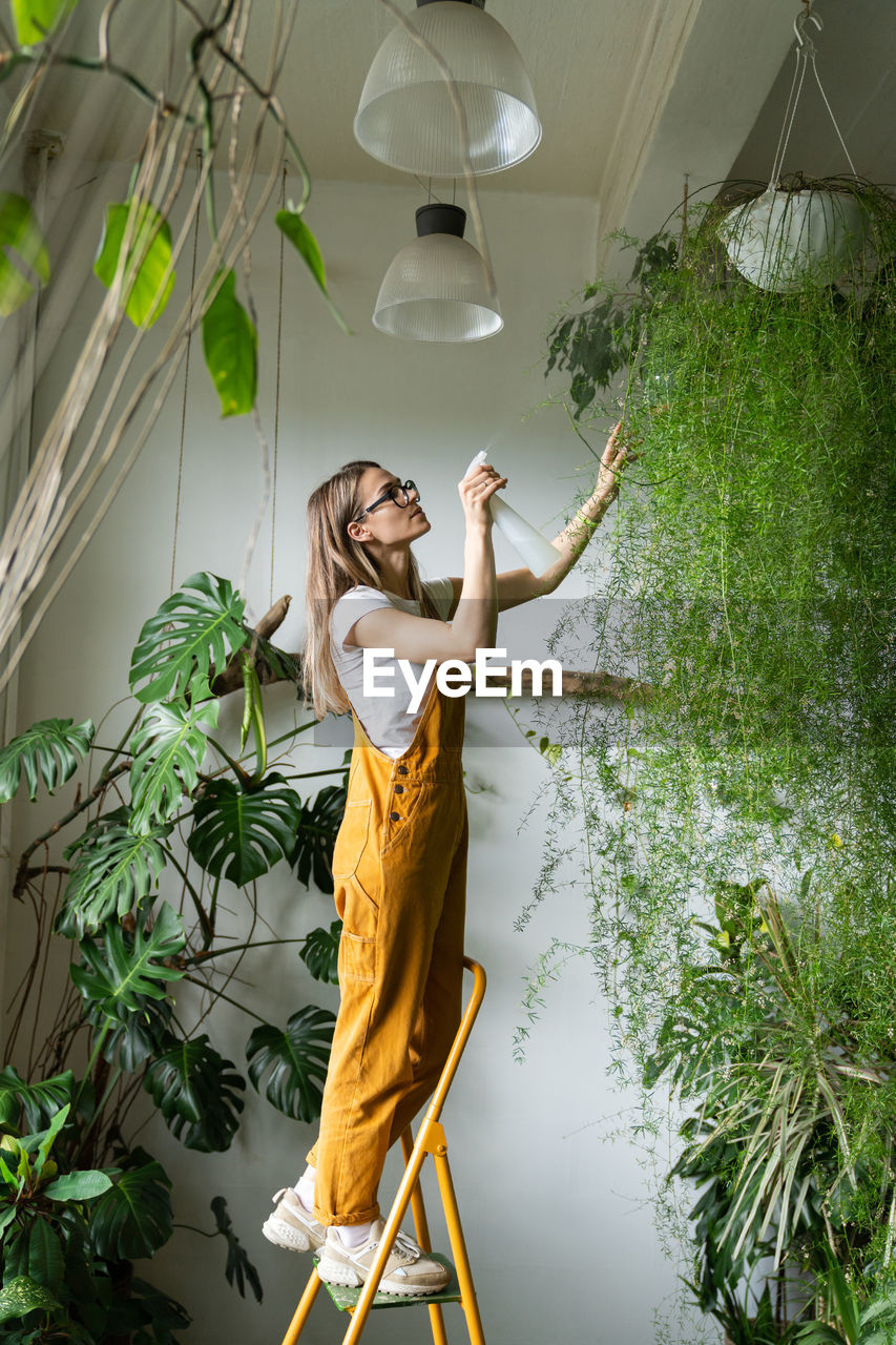 Woman watering plantings in workshop