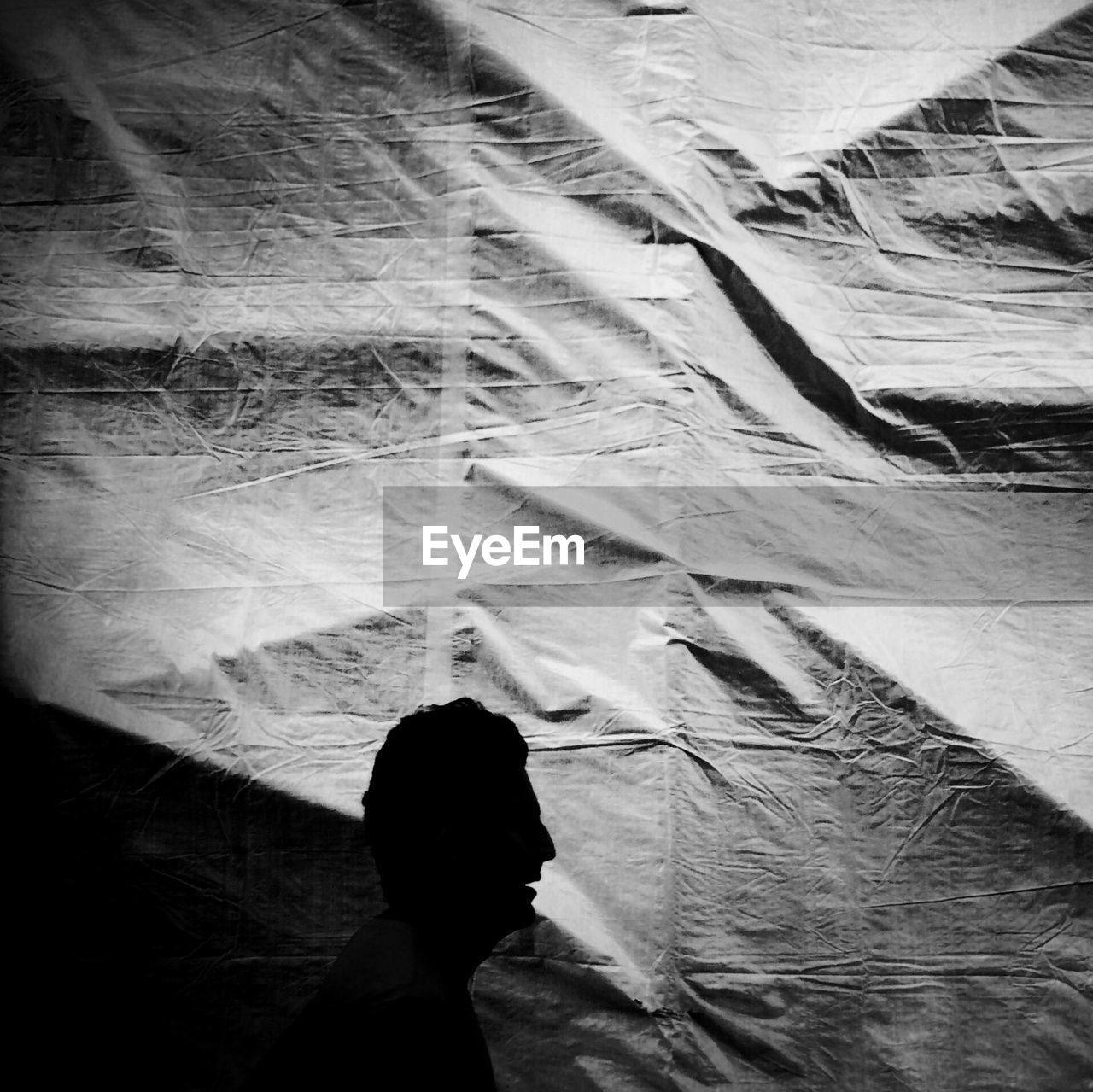 Silhouette man walking by tarpaulin at construction site