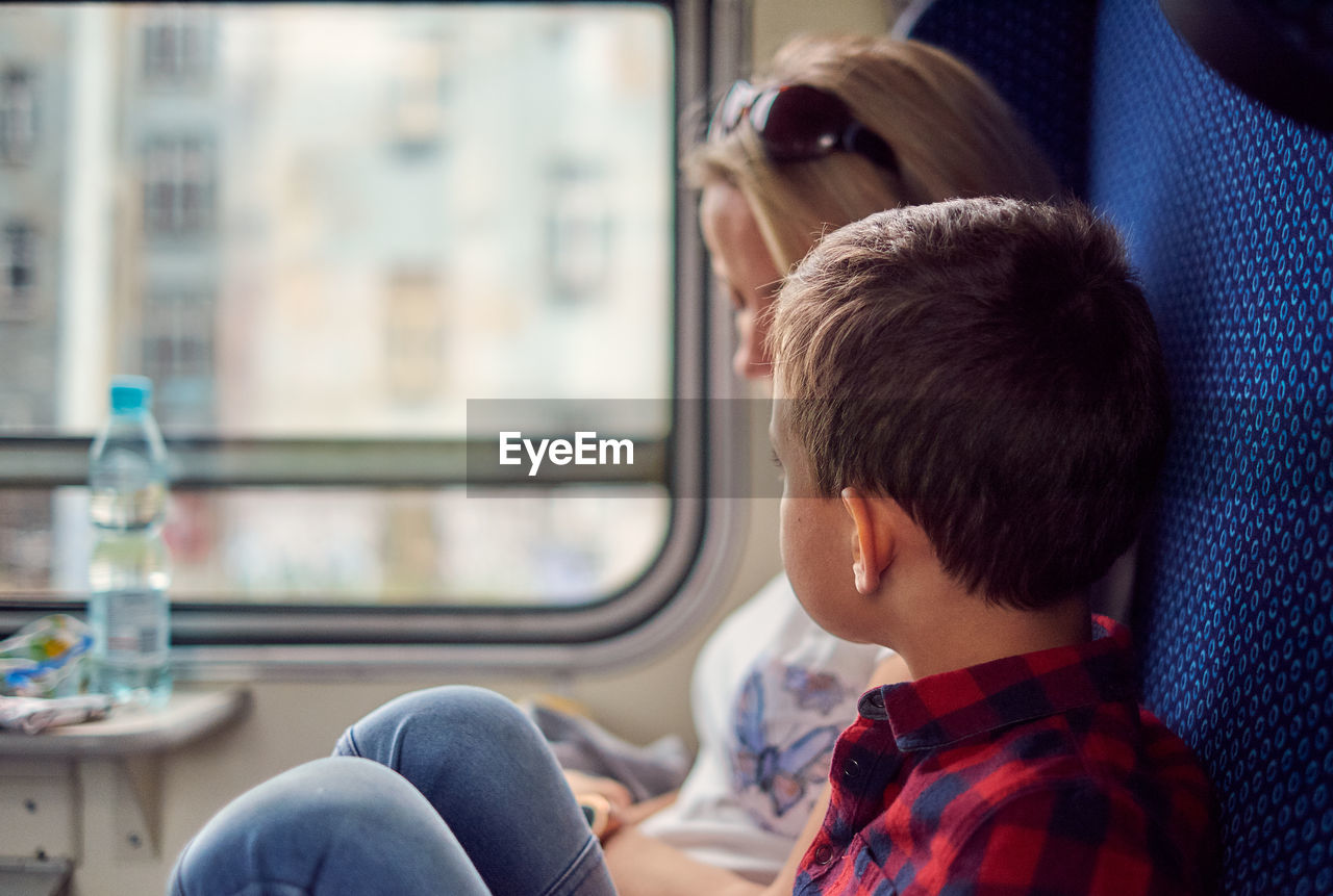 Boy sitting with mother in train