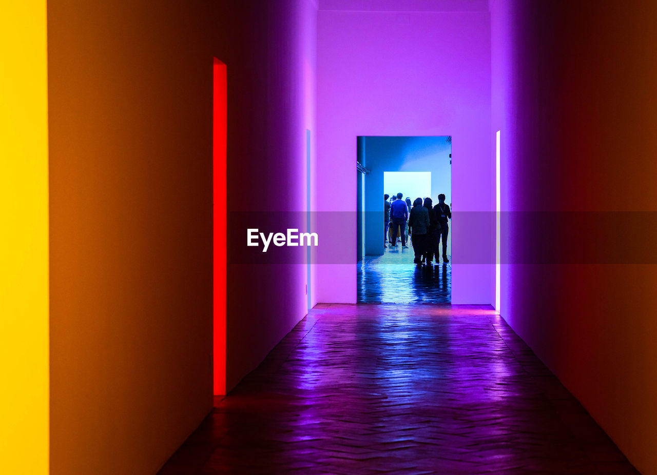 Rear view of people walking in room