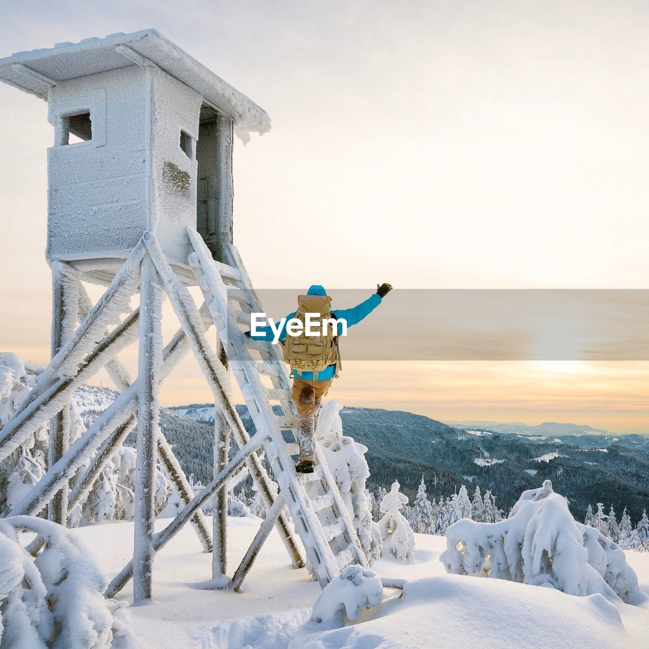 MAN STANDING IN SNOW AGAINST SKY