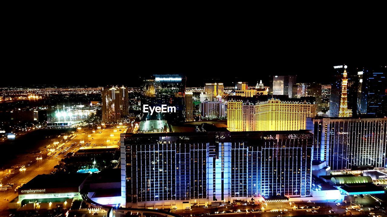 VIEW OF ILLUMINATED CITYSCAPE AT NIGHT