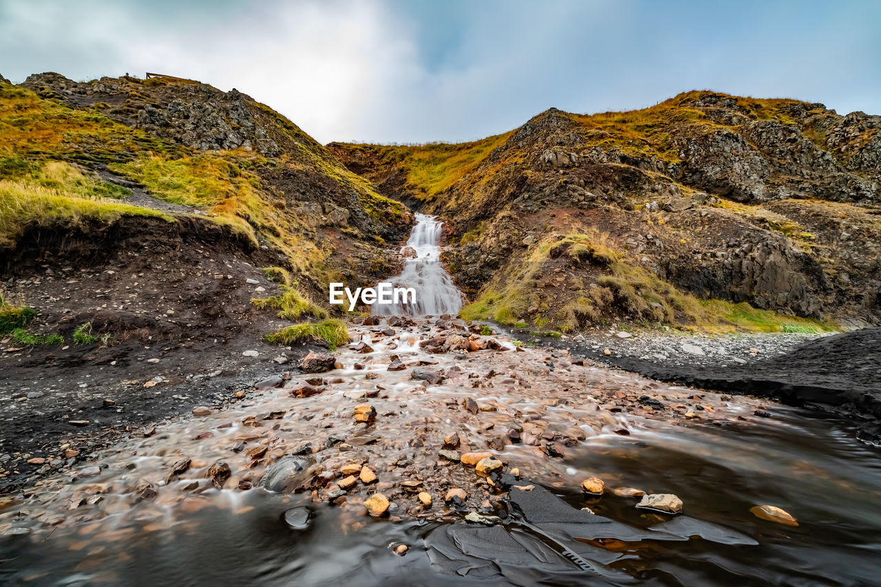 Scenic view of waterfall against sky