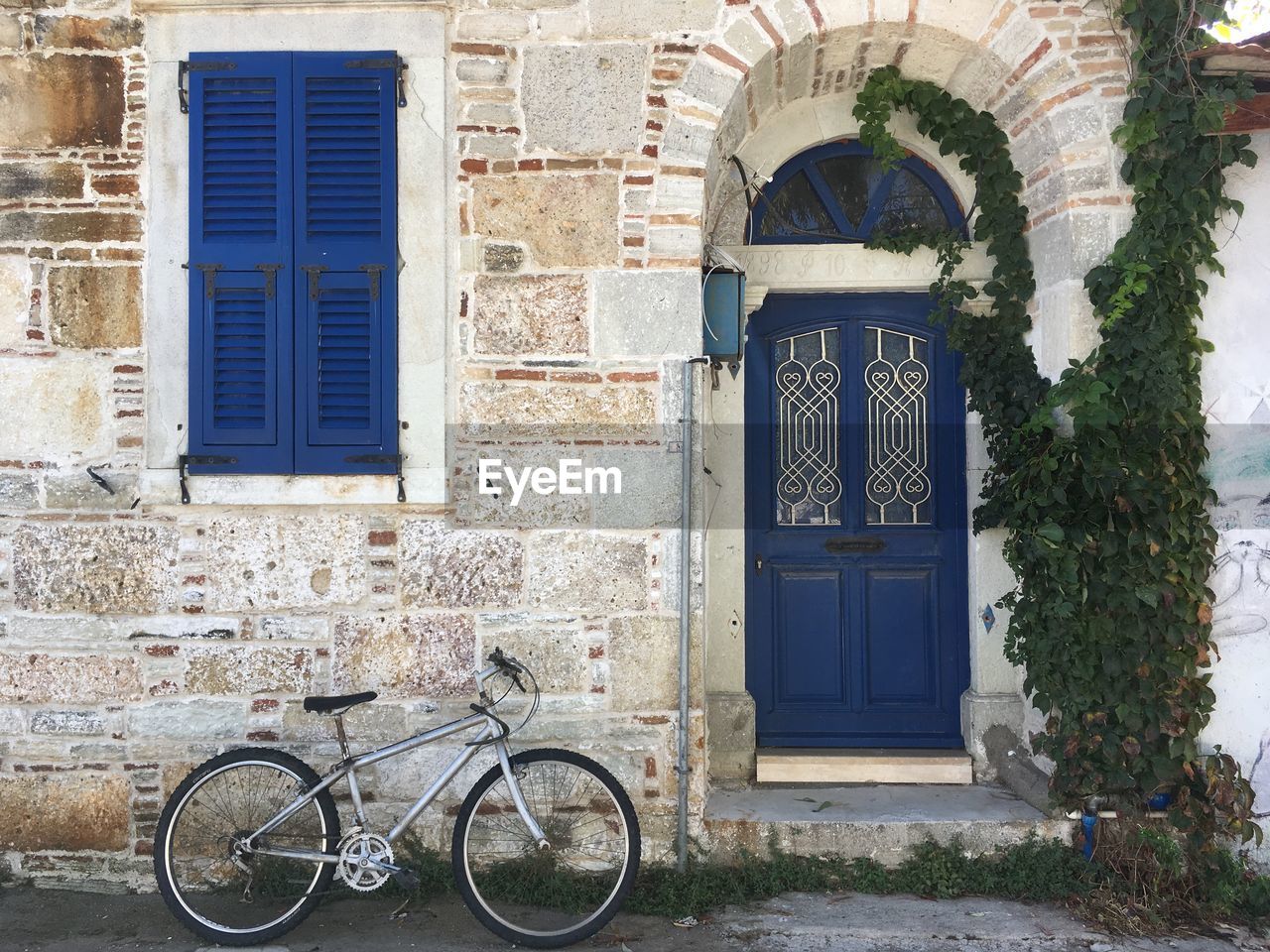 BICYCLE PARKED AGAINST BUILDING