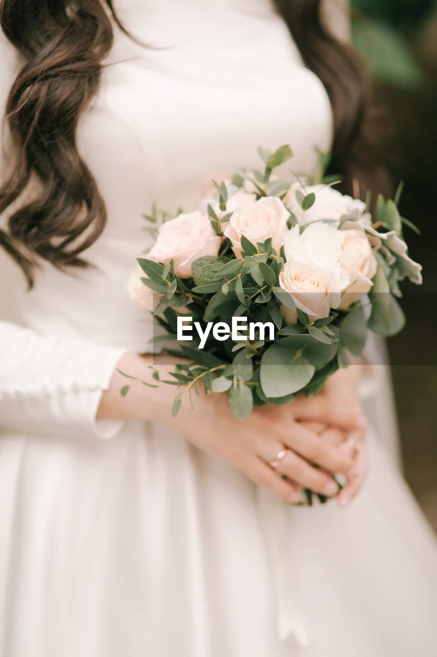 Midsection of woman holding flower bouquet