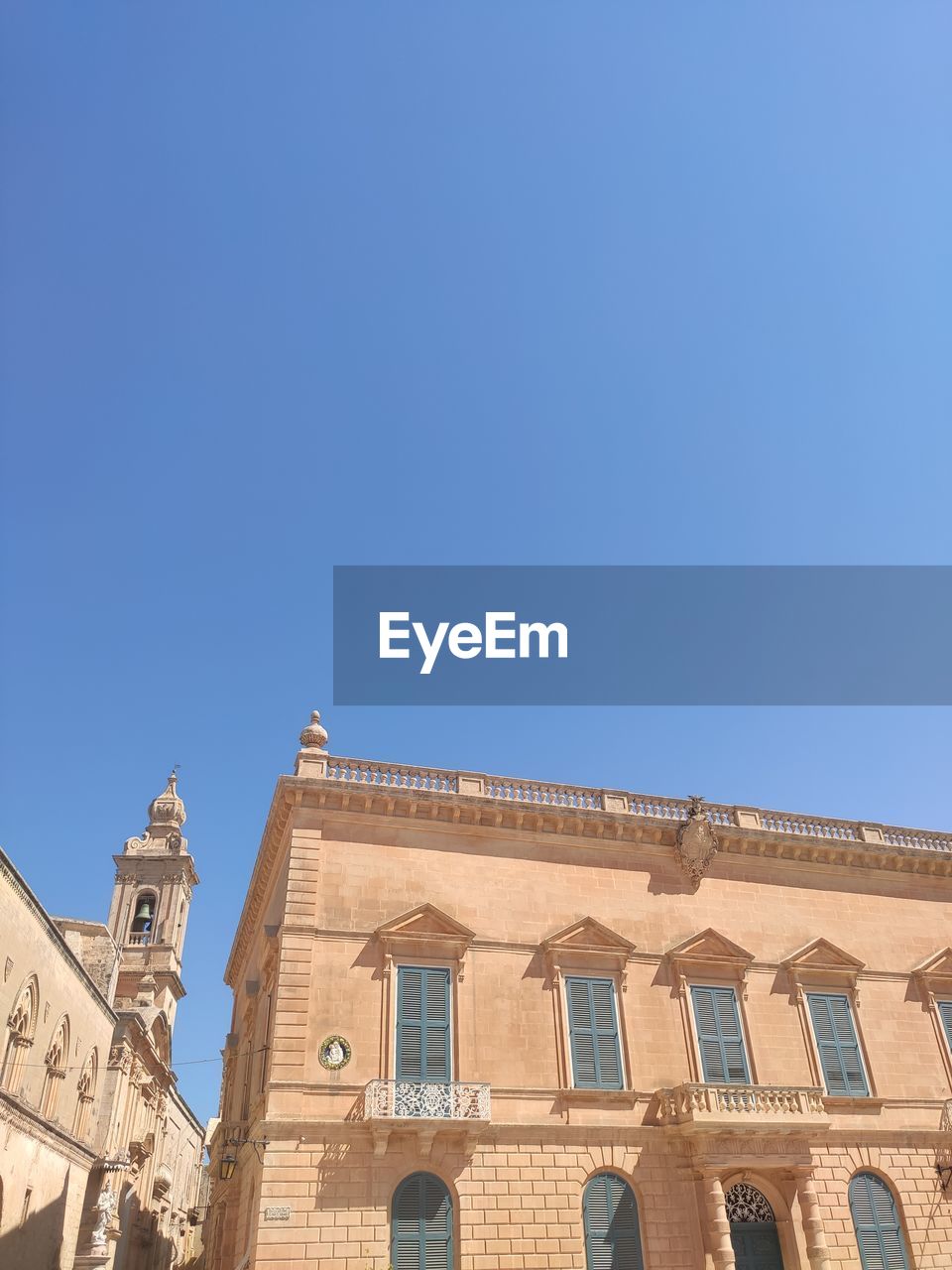 Low angle view of building against clear blue sky