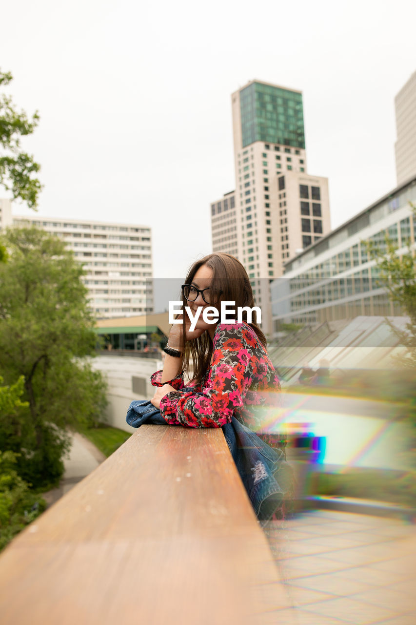 Portrait of woman sitting in city