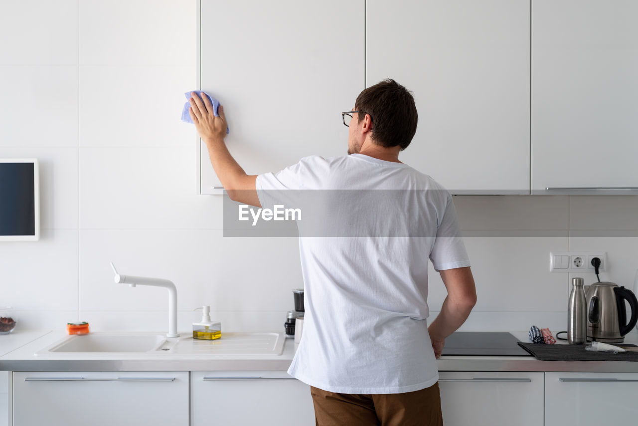 Rear view of man standing at home