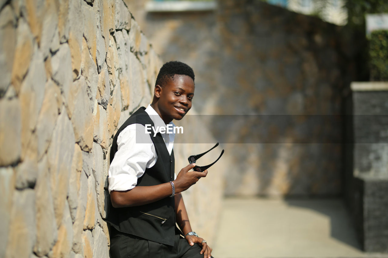 Young man standing against wall