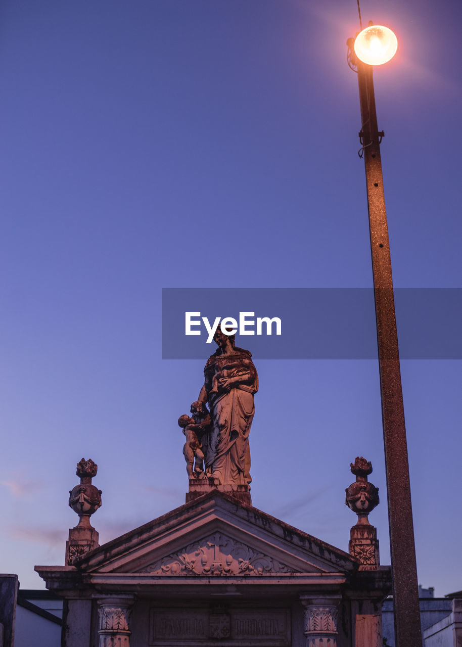 Low angle view of statue against blue sky