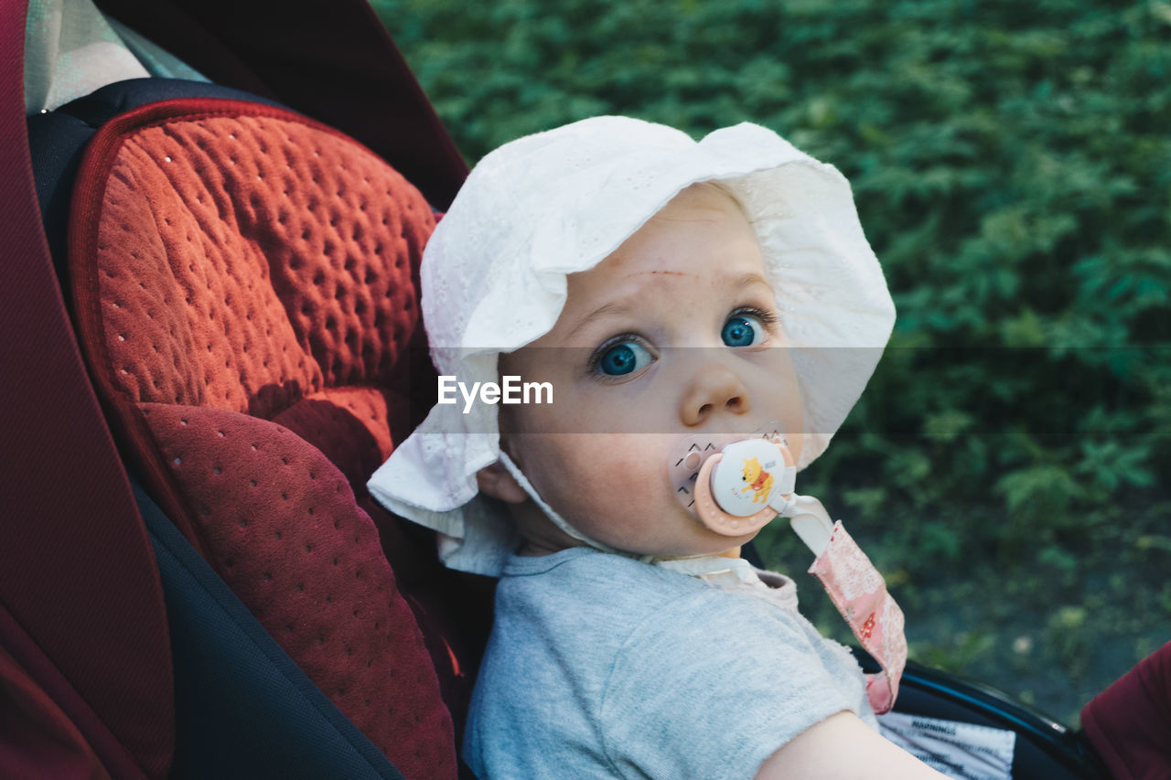 Portrait of cute baby girl siting in stroller