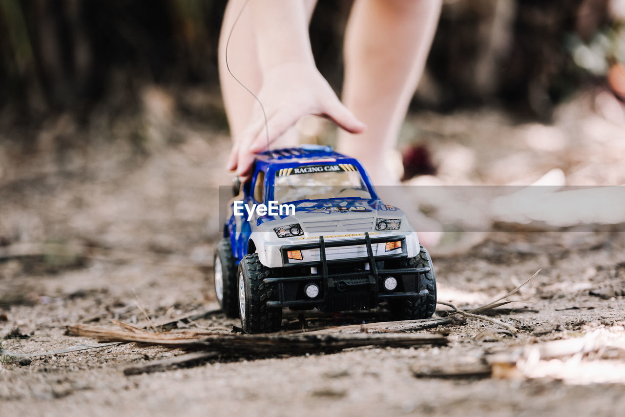 Close-up of child playing with toy car outdoors