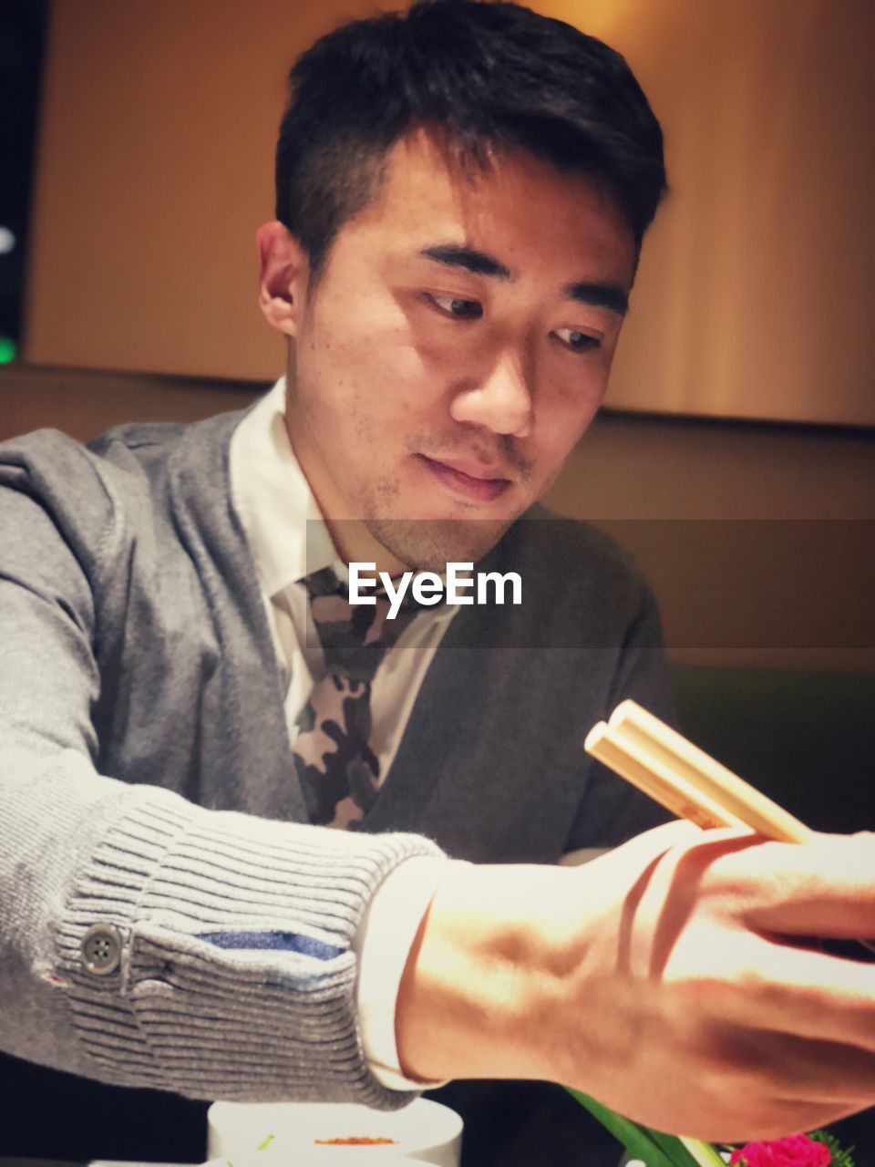 CLOSE-UP PORTRAIT OF YOUNG MAN HOLDING WOMAN SITTING AT HOME