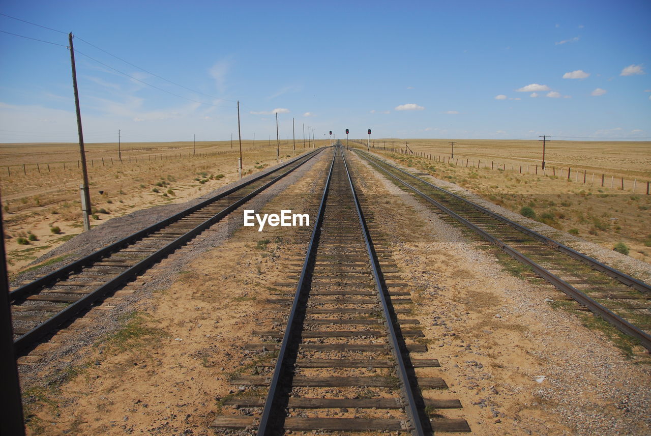 Railroad tracks against blue sky