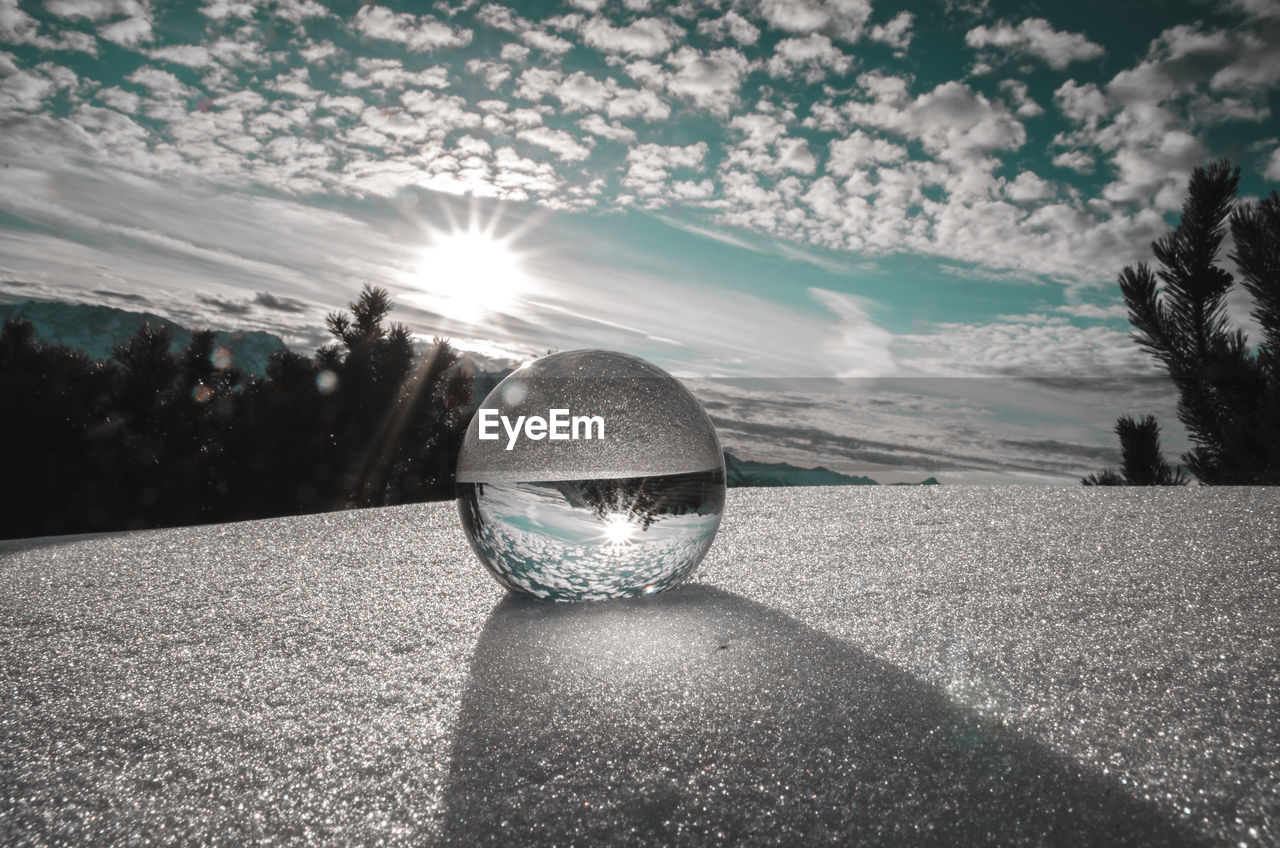 CLOSE-UP OF CRYSTAL BALL WITH REFLECTION ON ROAD