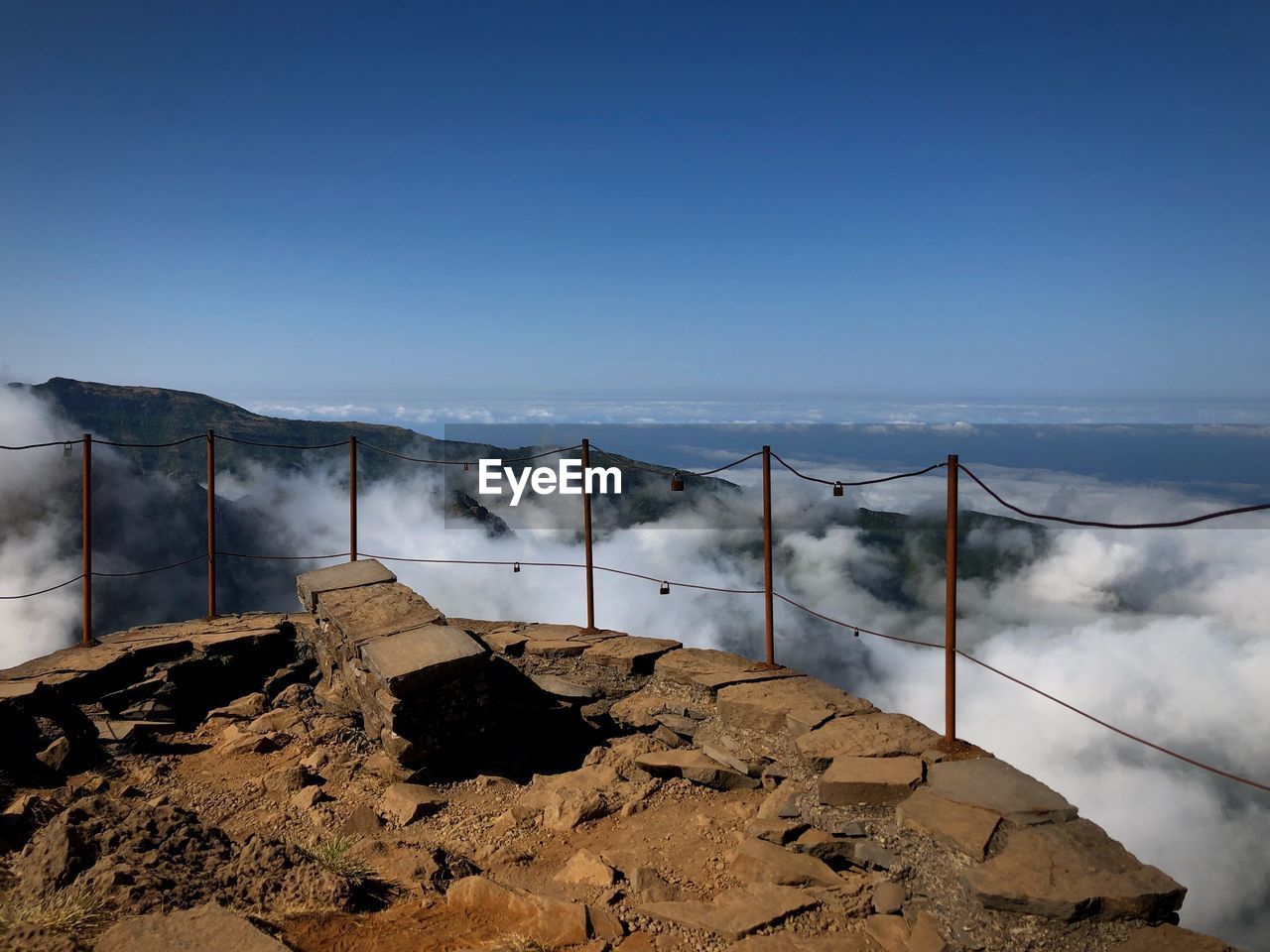 Fence on mountain against sky