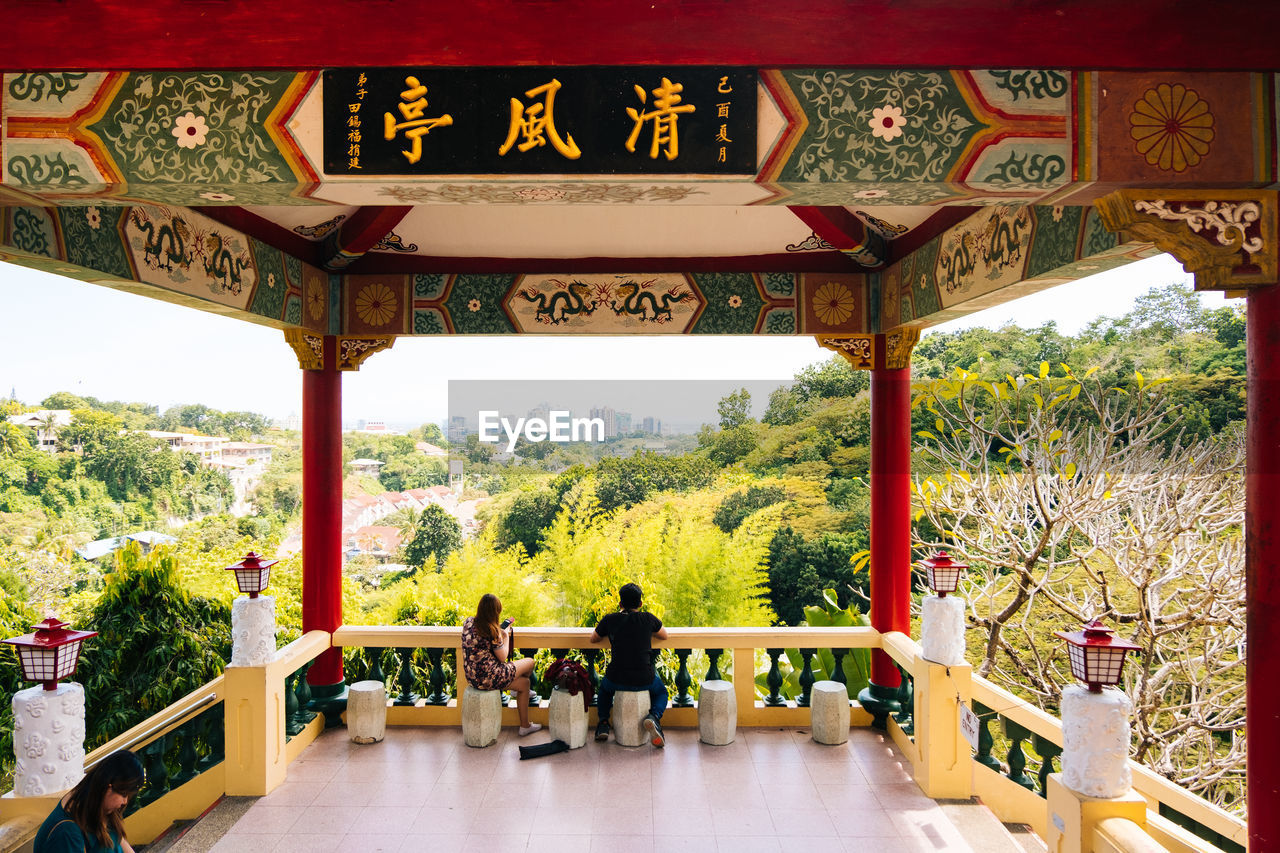 GROUP OF PEOPLE AT TEMPLE AGAINST CLEAR SKY