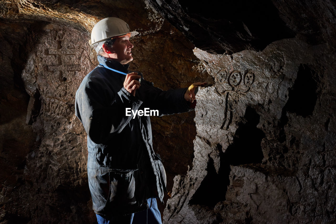 Man wearing helmet standing in cave