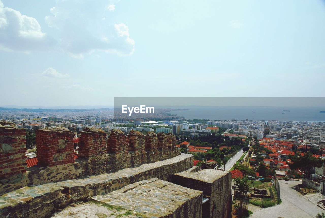 View of cityscape against cloudy sky