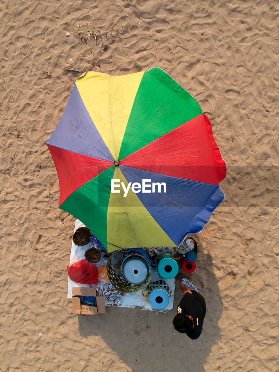 High angle view of man standing by objects for sale at beach