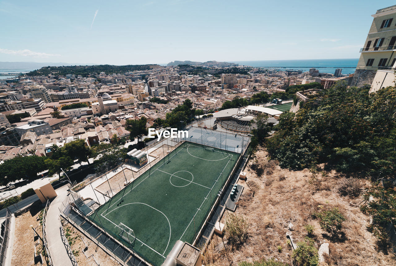 High angle view of soccer field and buildings in city