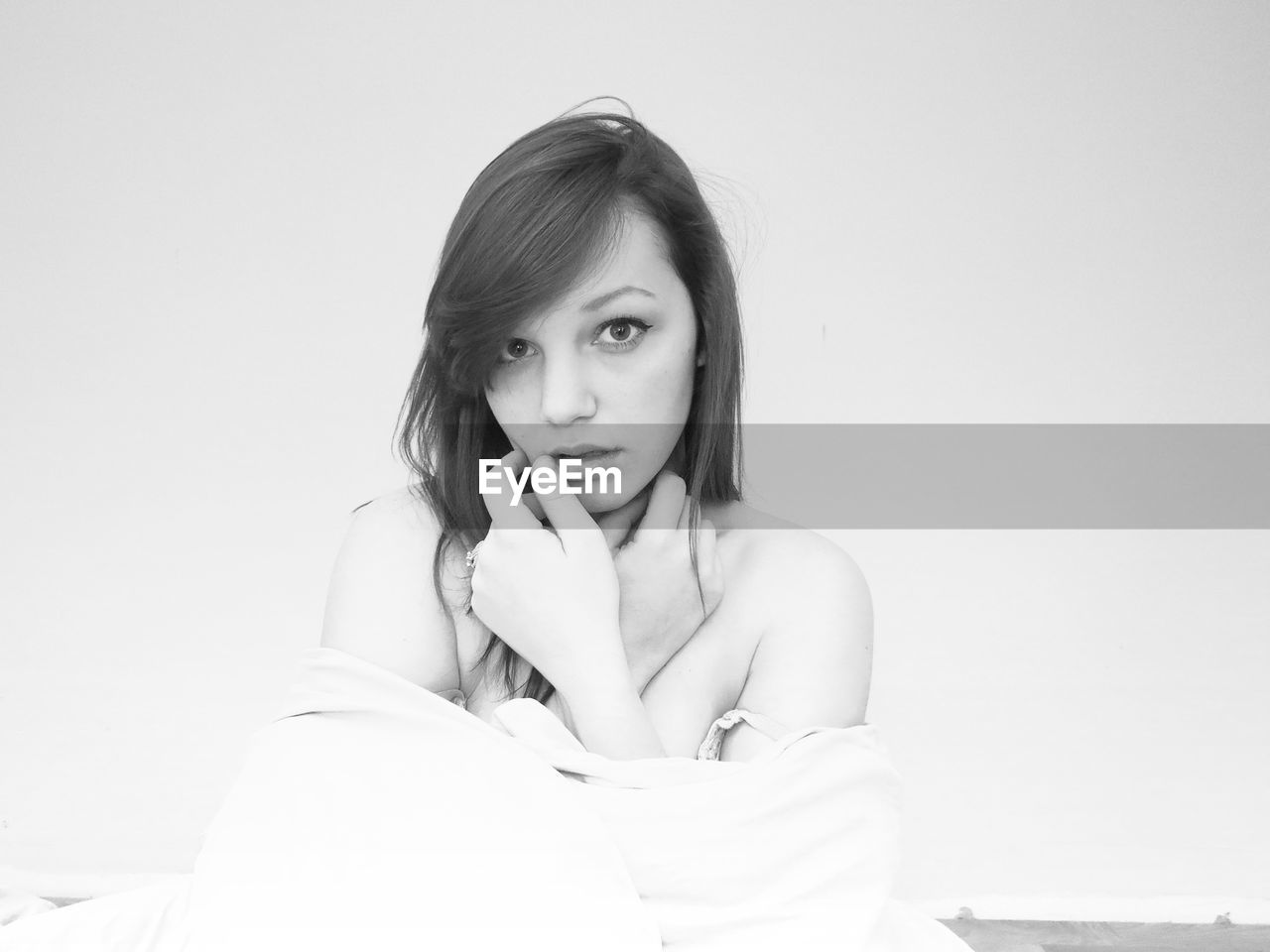 Portrait of young woman against wall