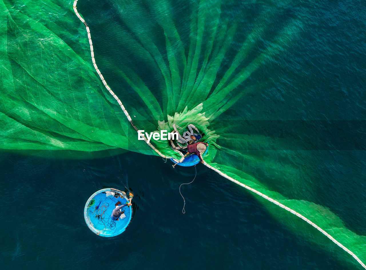 Drone shot of fisherman putting fishing net in sea