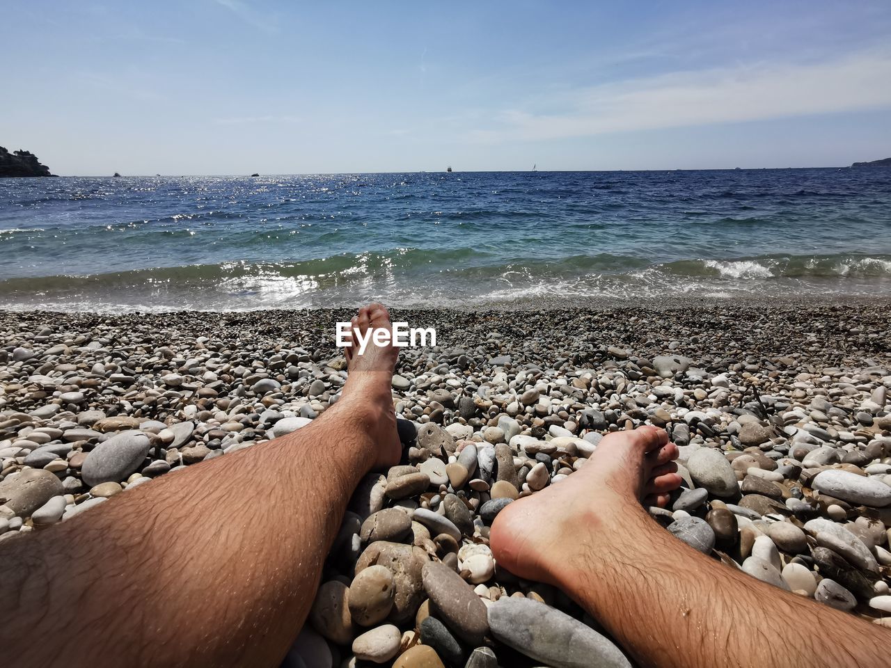 LOW SECTION OF PEOPLE ON ROCK AT BEACH