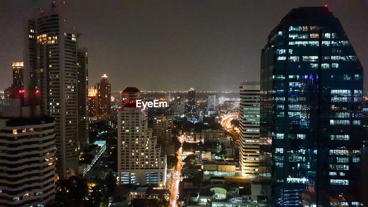 Illuminated buildings in city against sky at night