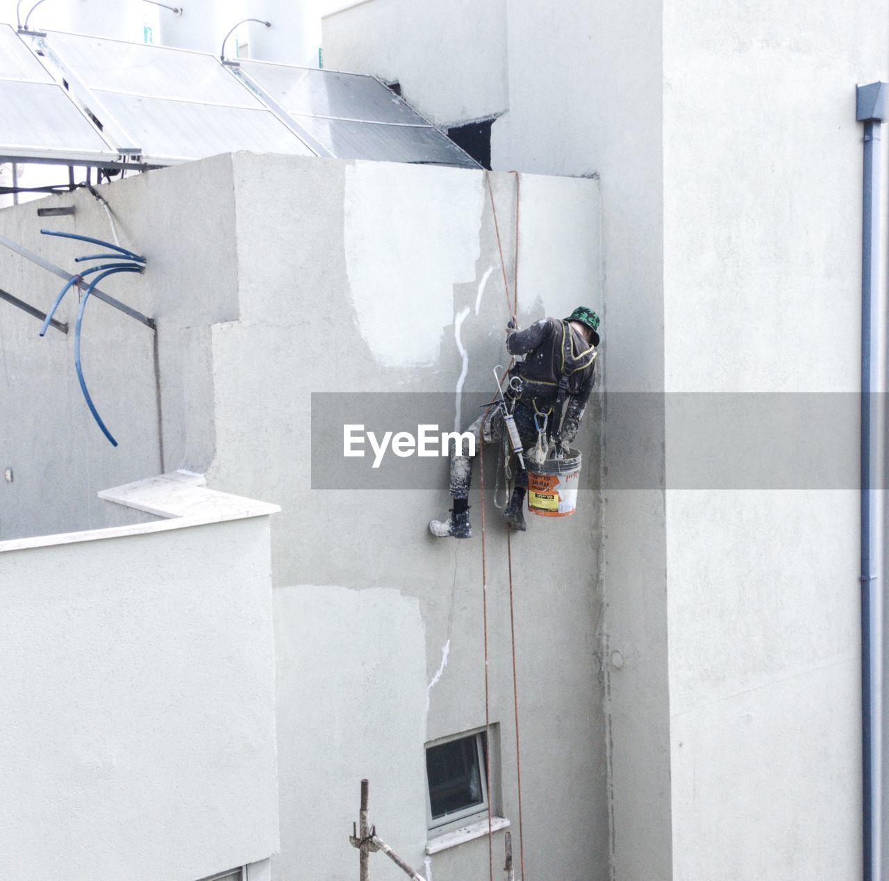 Climber working at construction site against building