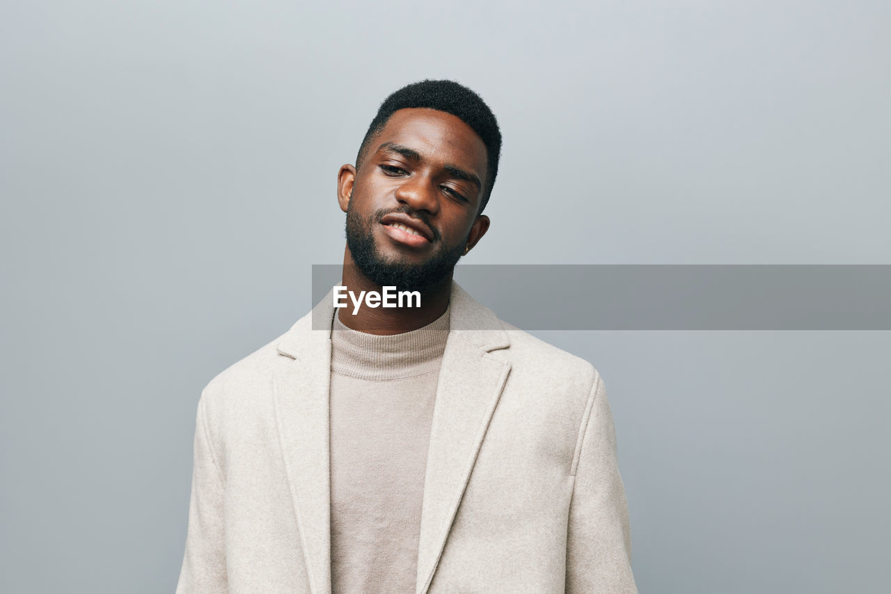 portrait of young man standing against clear sky