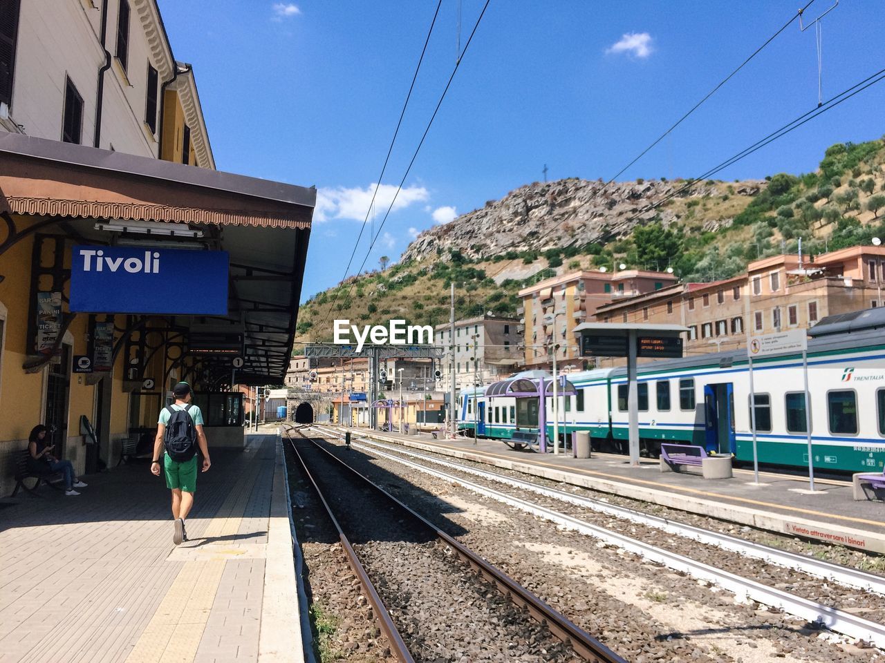 Rear view of man walking at railroad station