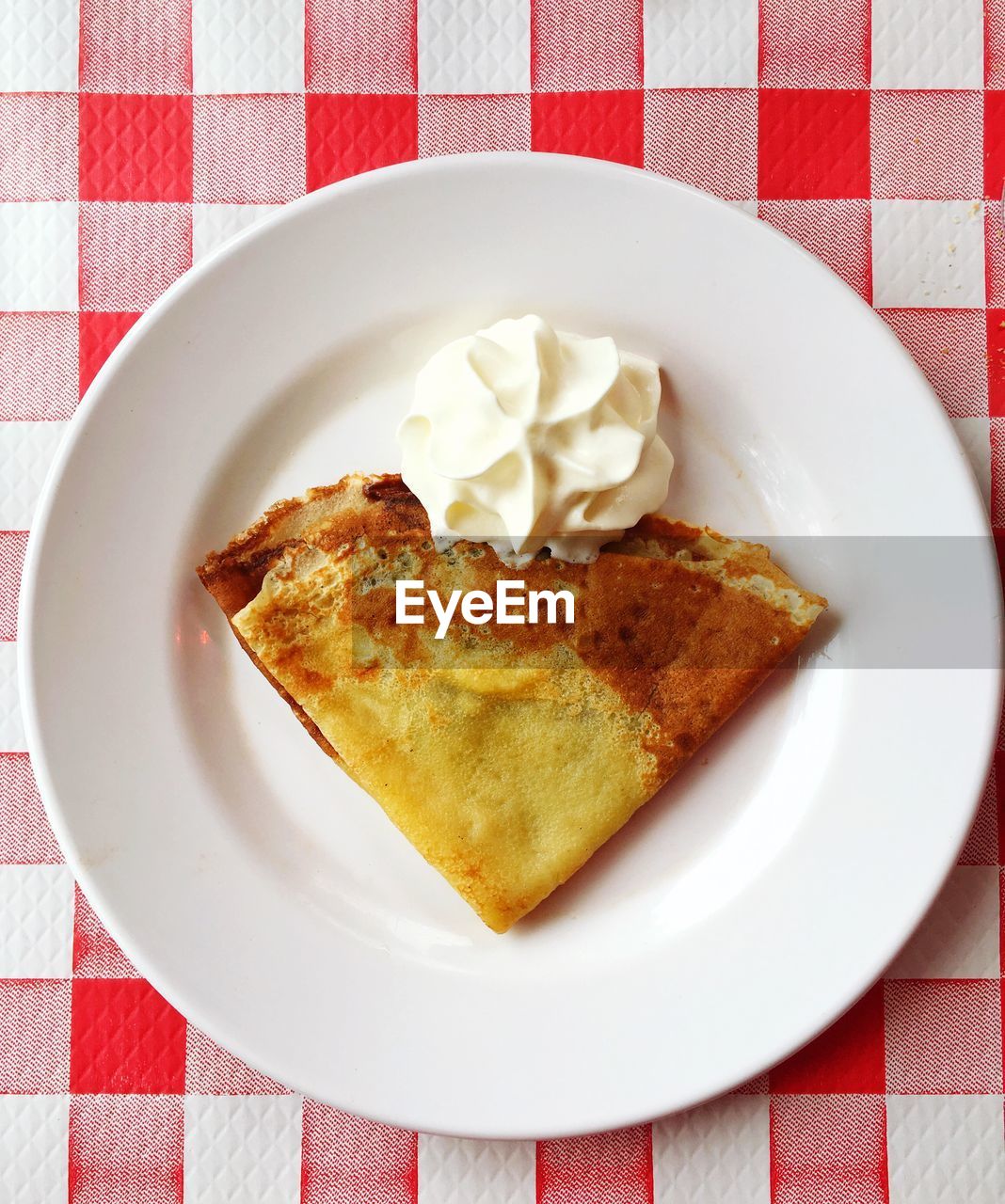 High angle view of crepe and whipped cream in plate on table