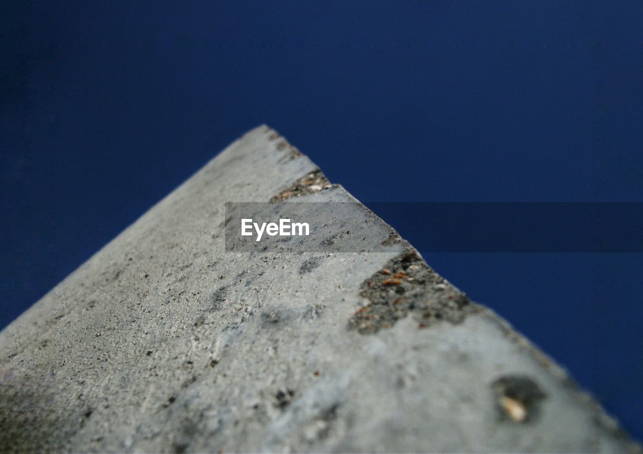 LOW ANGLE VIEW OF WALL AGAINST CLEAR BLUE SKY