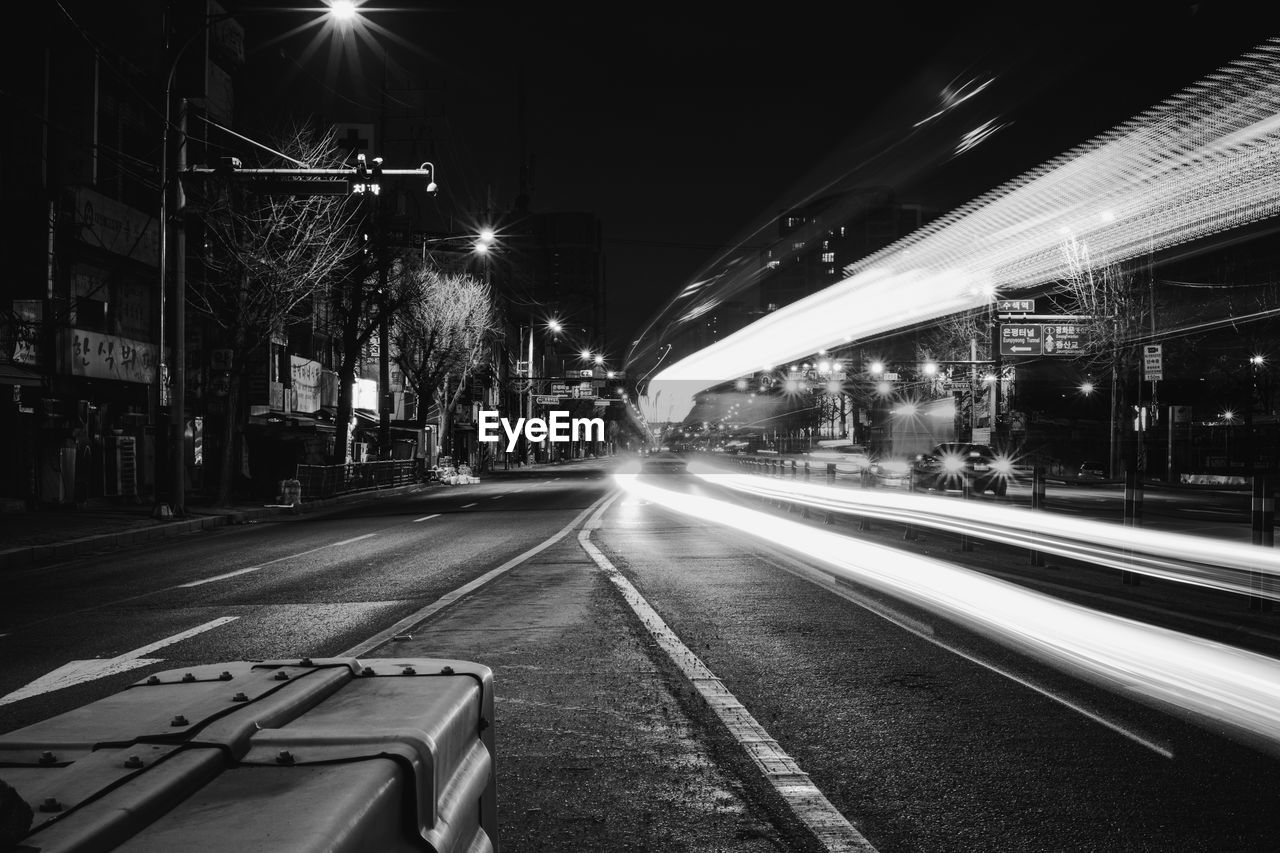 LIGHT TRAILS ON STREET AT NIGHT