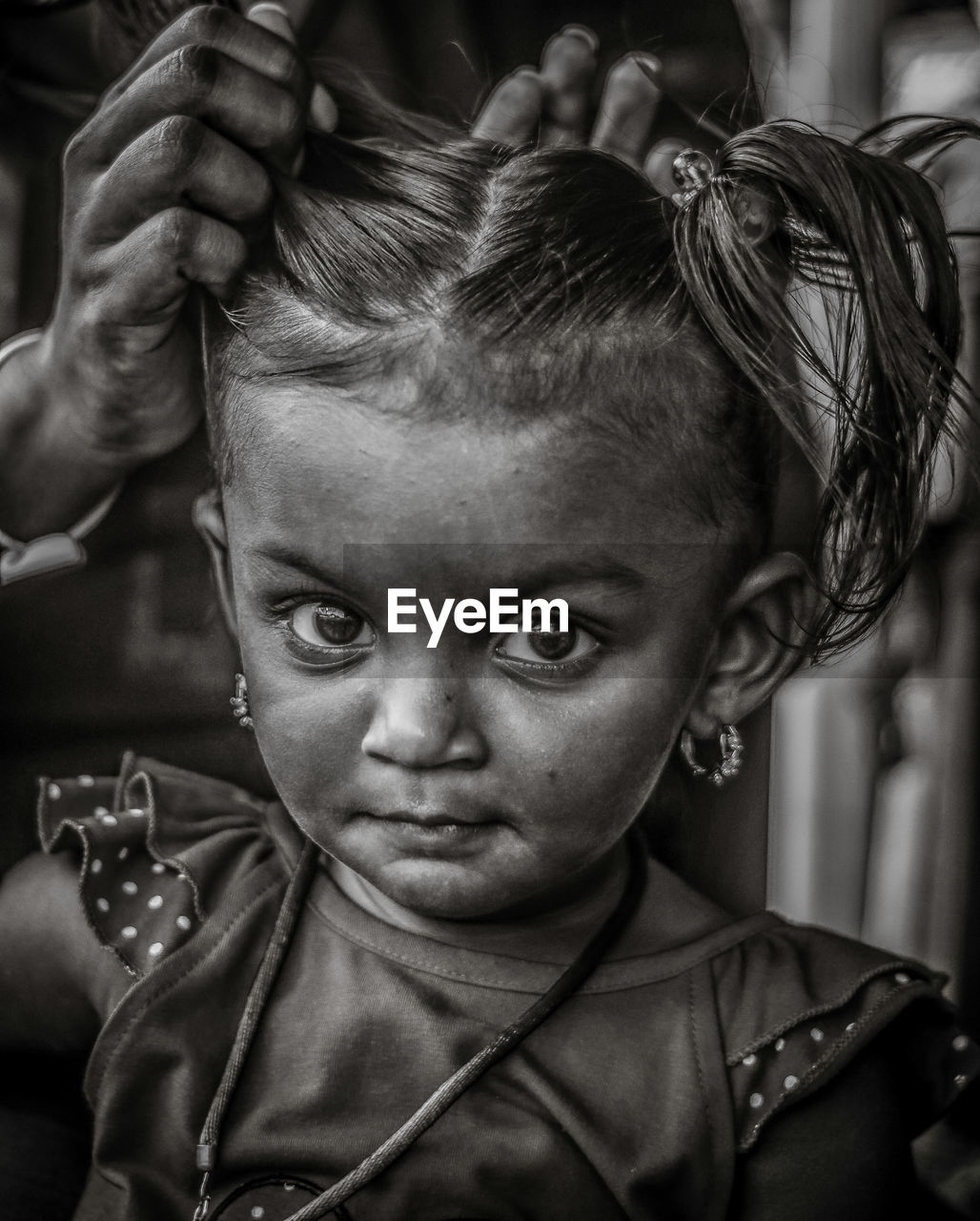 Close-up of mother tying girl hair