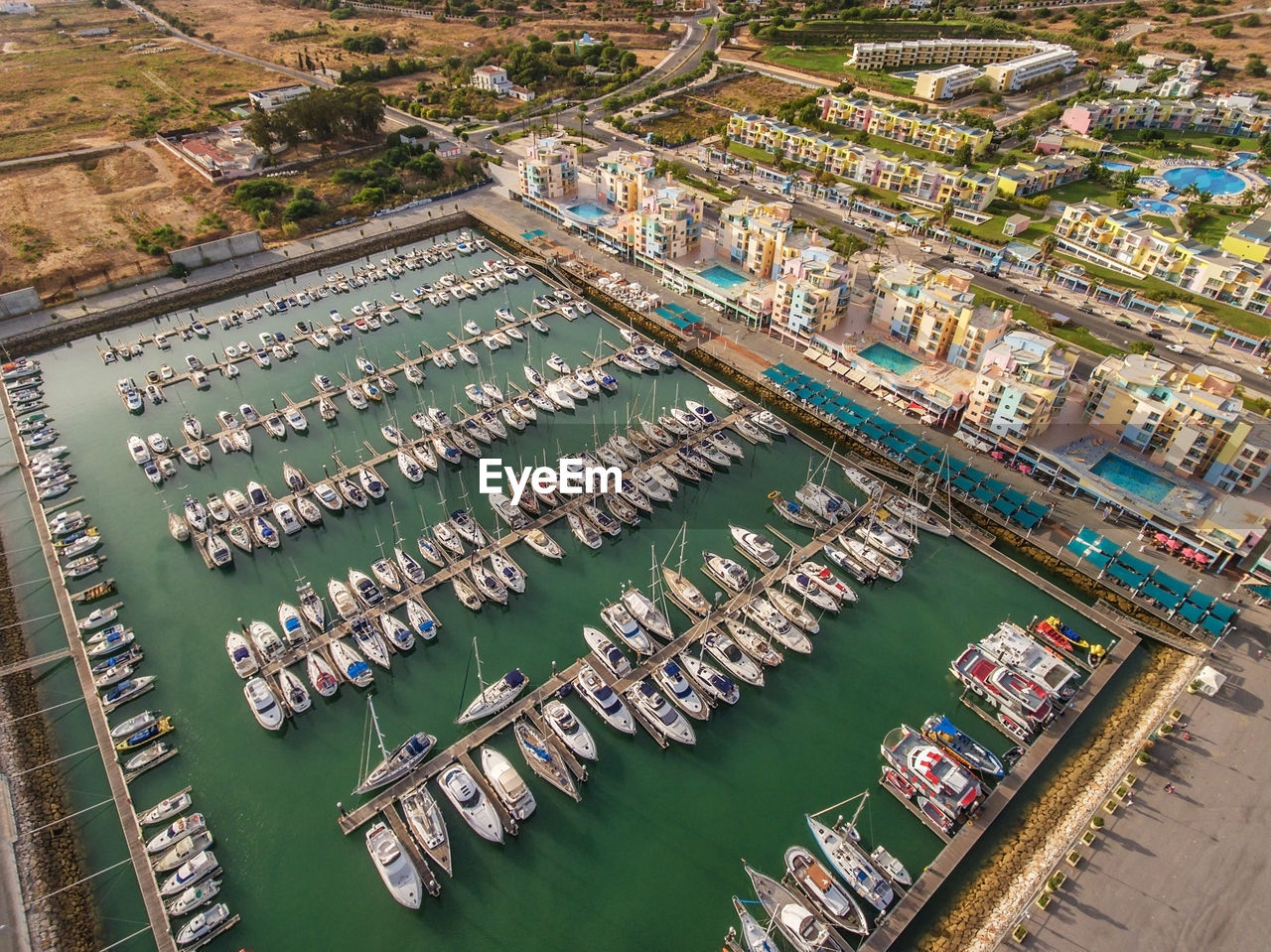 HIGH ANGLE VIEW OF COMMERCIAL DOCK AGAINST SEA