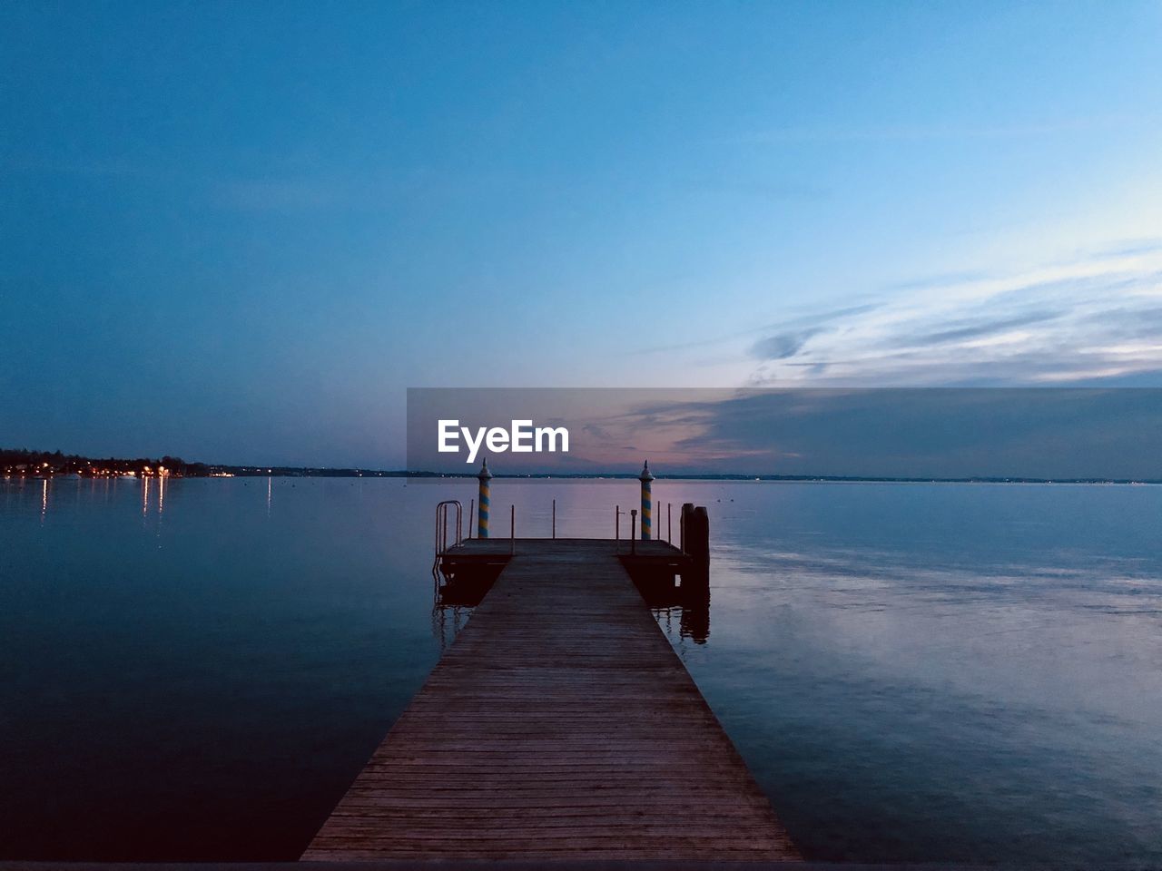 Pier over sea against sky during sunset