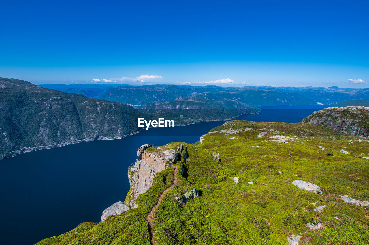 Scenic view of mountains against blue sky