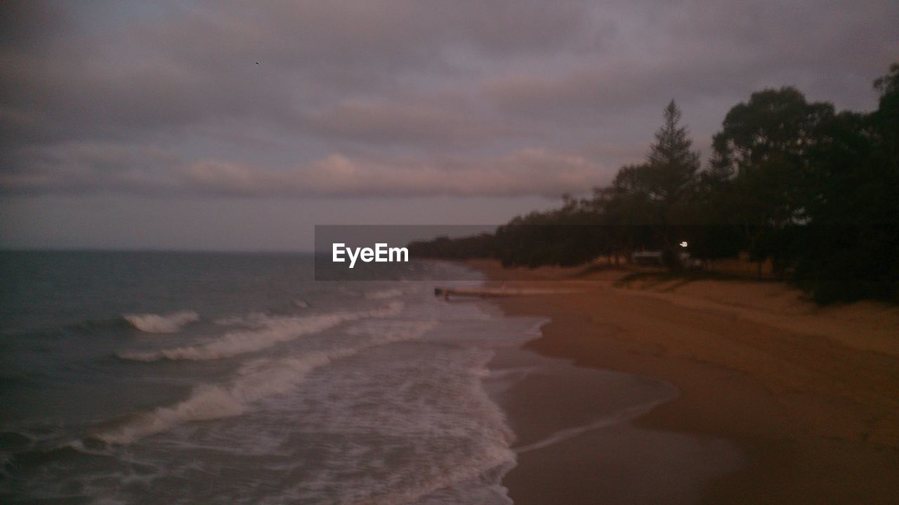 SCENIC VIEW OF SEA AGAINST CLOUDY SKY DURING SUNSET