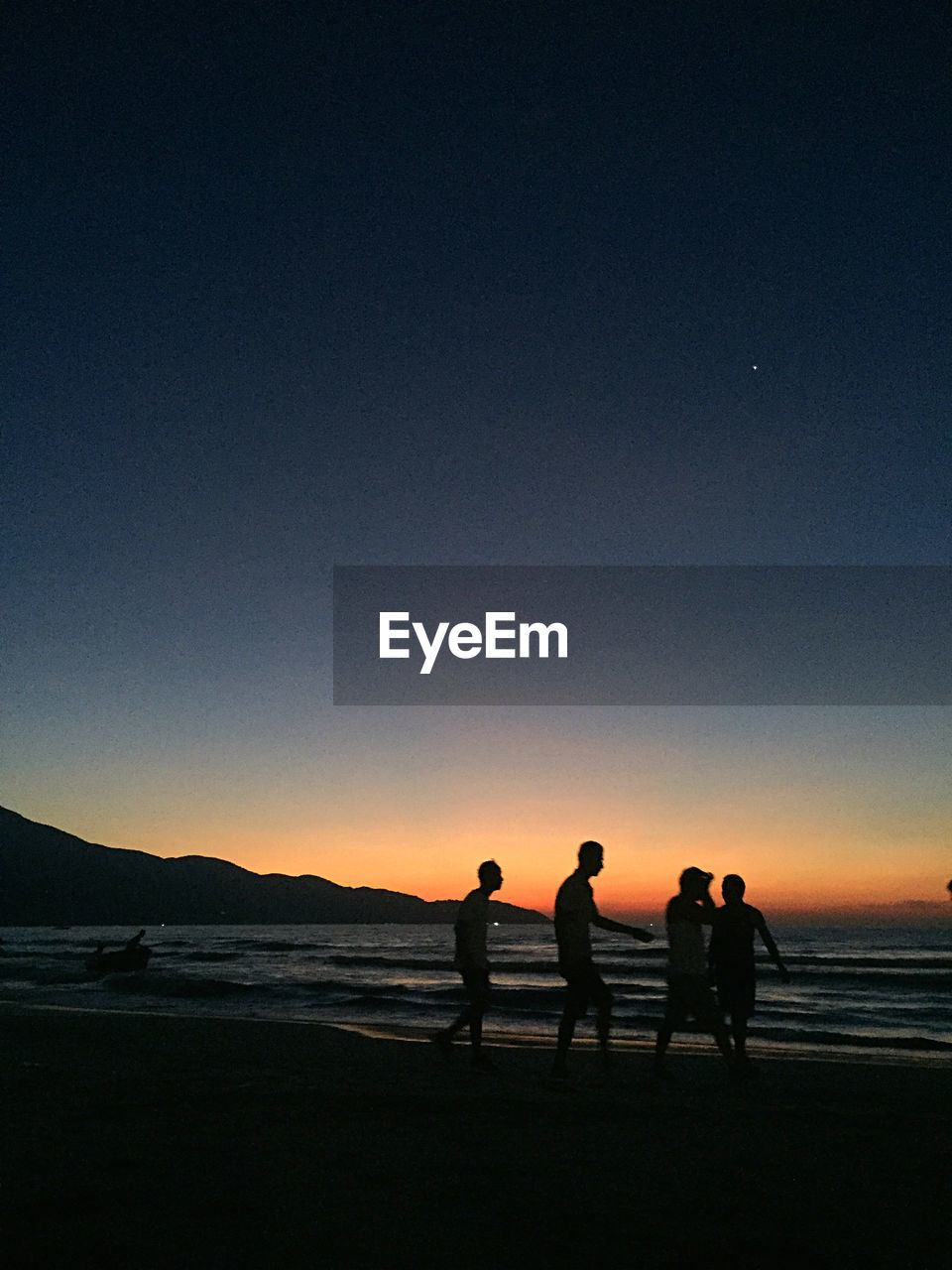 SILHOUETTE PEOPLE ON BEACH AGAINST CLEAR SKY