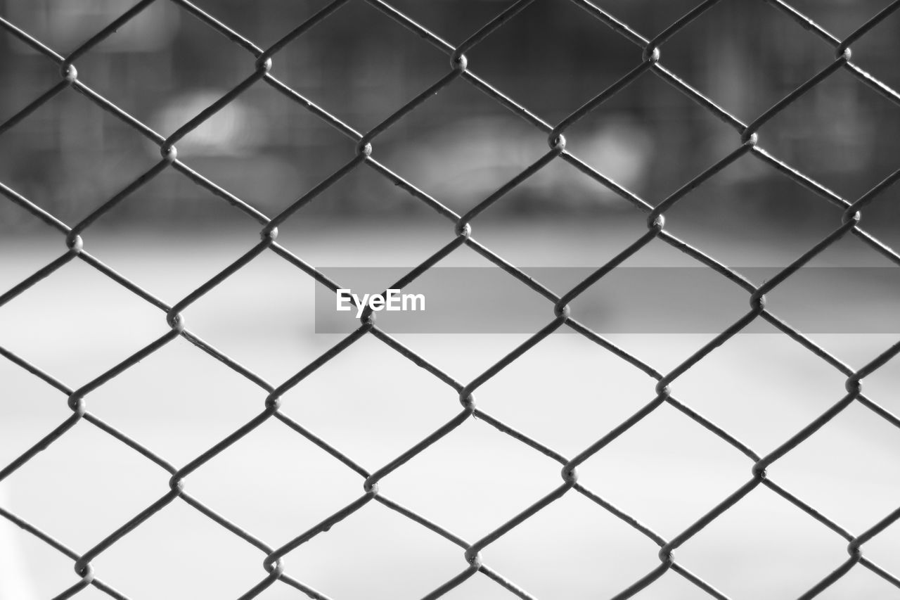 FULL FRAME SHOT OF CHAINLINK FENCE AGAINST THROUGH METAL RAILING