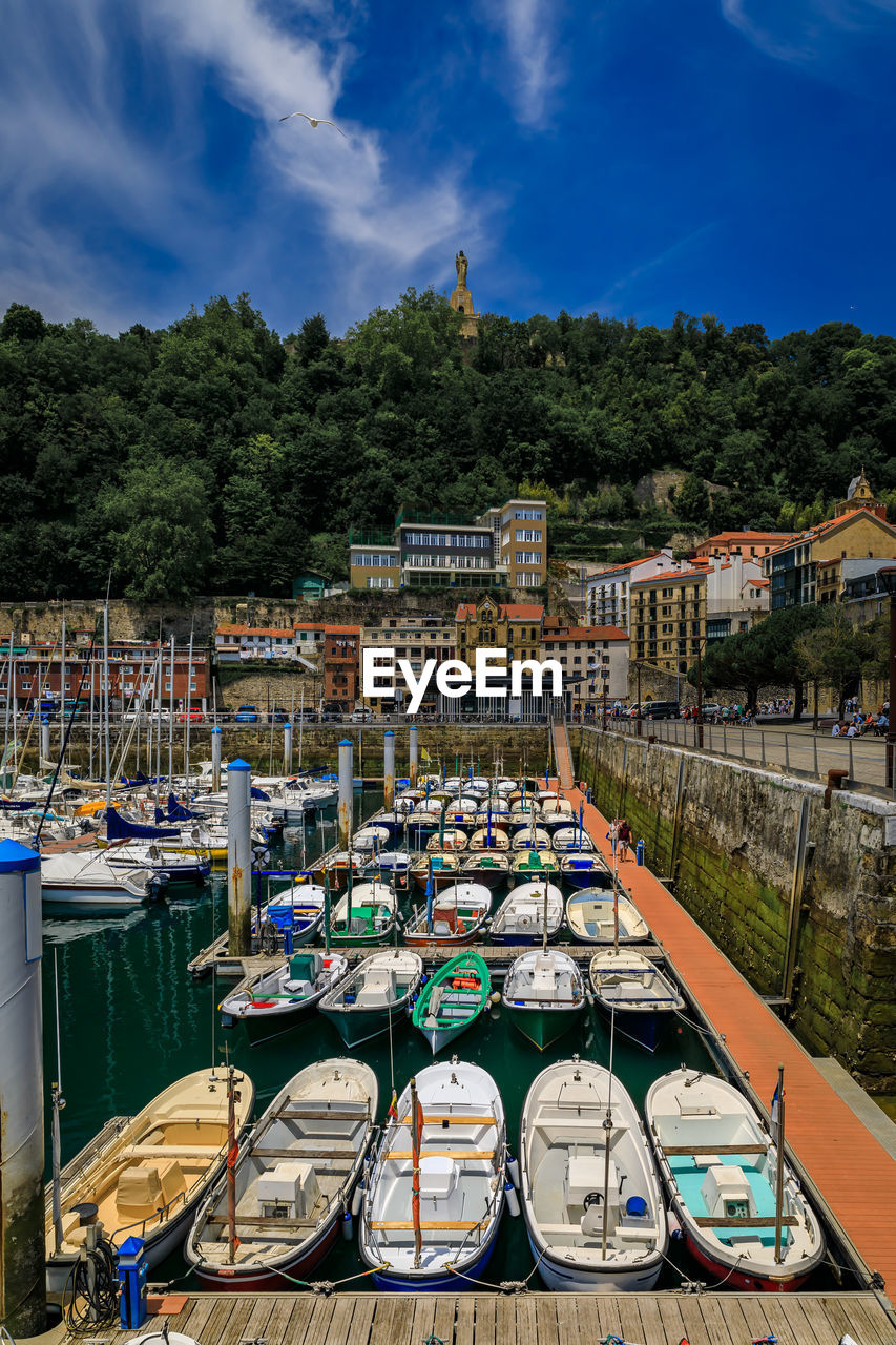 boats moored at harbor against sky