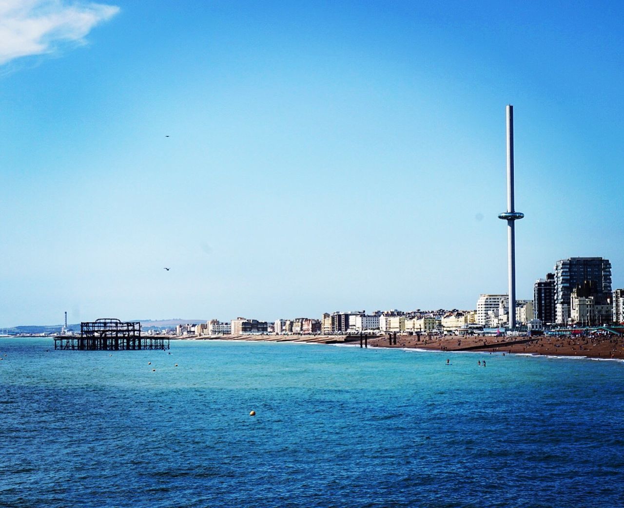Scenic view of sea by buildings against sky 