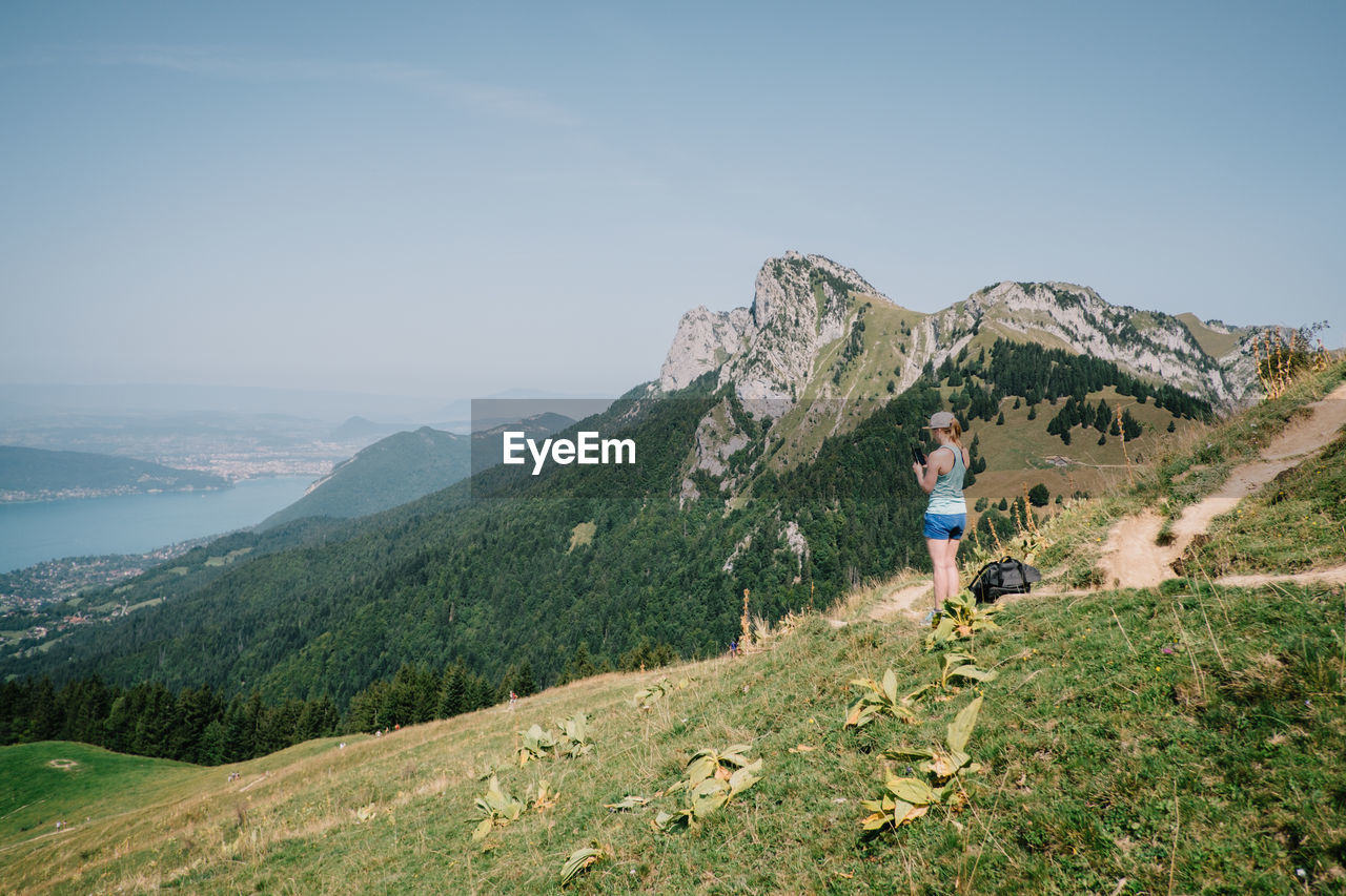 Woman standing on mountain against sky