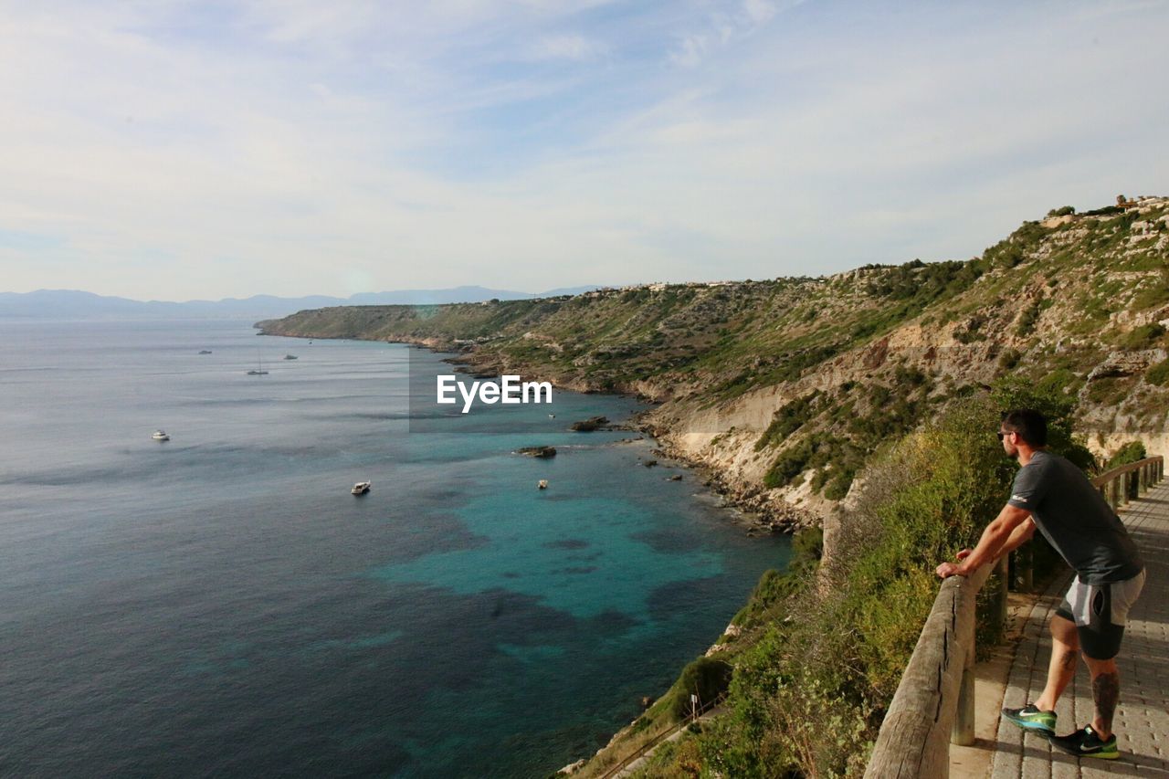 Side view full length of man on observation point looking at sea in majorca